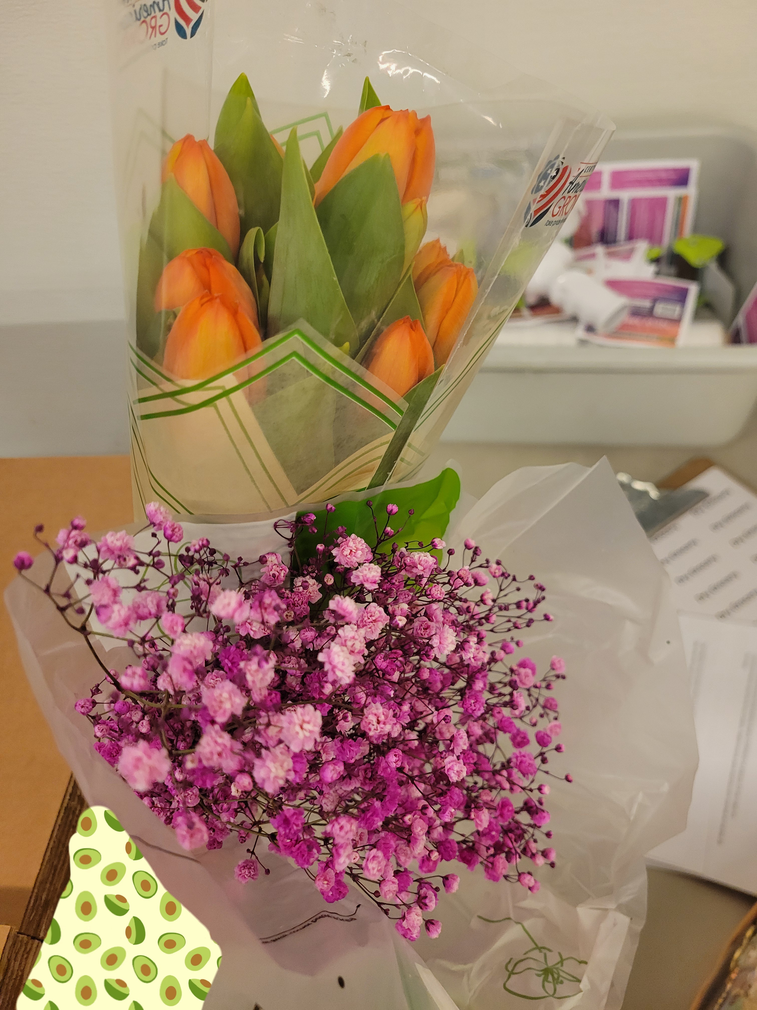 One bouquet of orange tulips and one bouquet of pink baby's breath.